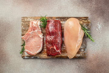 Wall Mural - raw meat assortment steaks beef, pork, chicken on dark background.