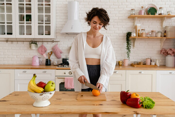 Wall Mural - young pretty woman cooking at home, morning kitchen, healthy food
