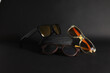 Three pairs of sunglasses with black case on black background