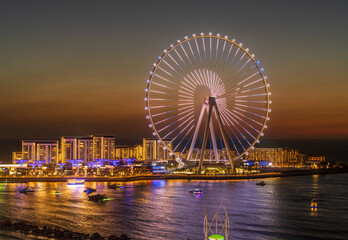 lights on structure of ain dubai observation wheel on bluewaters island at sunset