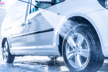 Poster - Manual car wash with white soap, foam on the body. Washing Car Using High Pressure Water.