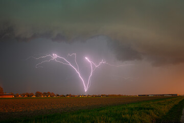 Wall Mural - upward lightning bolt initiated by a windturbine along highway a12 in the netherlands