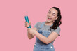 © New Africa - Young woman blowing up party popper on pink background, space for text