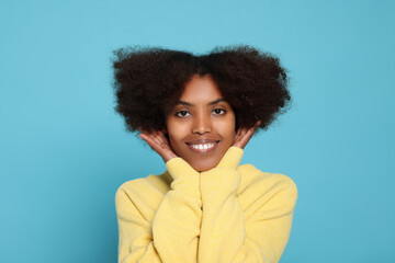 Wall Mural - Portrait of smiling African American woman on light blue background