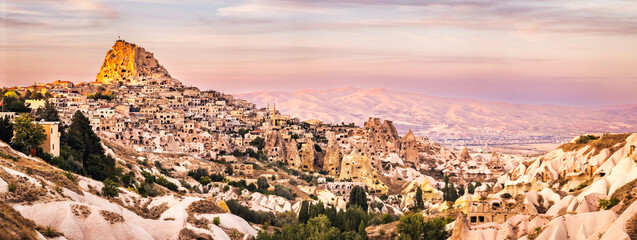 Wall Mural - Uchisar Castle panorama as viewed from Pigeon Valley at sunset. Situated on the edge of Goreme National Park, Uchisar consists of an old village huddled around the base of a huge rock cone