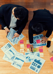 Poster - Top view analyst team discussing financial data on digital dashboard, analyzing chart and graph papers by data science software on wooden table background. Business intelligence and Fintech. Fervent