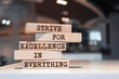 Wooden blocks with words 'Strive for excellence in everything'.