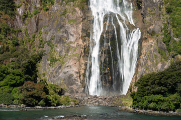 Wall Mural - Magnificent waterfall, Milford Sound (Piopiotahi) fjord, Fiordland National Park in the south west of New Zealand's South Island. World heritage site among the world's top travel destinations