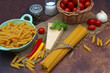 Zutaten für italienische Pasta Gerichte: Spaghetti, Nudeln, Parmesan, Käse, Tomaten, Paprika und Gewürze Gewürze auf Sackleinen.	