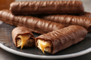 Sweet tasty chocolate bars with caramel on plate, closeup