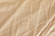 © New Africa - Crumpled beige fabric as background, top view