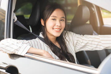 Transport concept, happy smile brunette hair asian young woman driving, getting new car, vehicle for travel, trip with face positive, female driver car with fasten safety seat belt before traveling.
