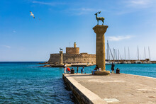 Mandraki Port With Deers Statue, Where The Colossus Was Standing And Fort Of St. Nicholas. Rhodes, Greece. Hirschkuh Statue In The Place Of The Colossus Of Rhodes, Rhodes, Greece