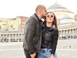 © Striker777 - Happy smiling beautiful  Tourists  couple traveling at  Naples Italy, poses and making photos  in front of  Piazza del Plebiscito , Italy.Concept of Italian gastronomy and travel. Italian couple