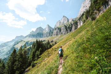 athletic woman walks on scenic hiking trail between meadow and trees and the churfürsten mountain ra