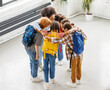 © JenkoAtaman - top view of group of schoolchildren and a teacher standing together hugging each other and consulting, keeping secrets