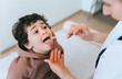 © Iona - Female doctor checking Childs throat of little curly boy using medical wand for examination at hospital. Hispanic toddler shows tongue to nurse. Children medical care and healthy lifestyle.