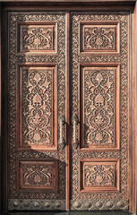 Wall Mural - Carved wooden doors with gilded metal handles..