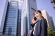 © dach_0418 - オフィス街で電話をする日本人ビジネスウーマン