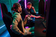 © Drobot Dean - Male friends discussing game strategy while playing online video game in cybersport club