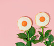 © Adela - Spring creative layout with fried eggs and rose flower stems on pastel pink background. 80s or 90s retro fashion aesthetic bloom concept. Minimal romantic surreal cosmetic idea.