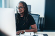 © Jacob Lund - Woman focusing on her computer screen as she works on a task in a business office