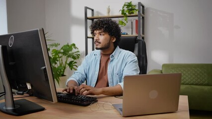 Kinky-haired programmer works on computer in home office