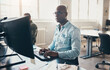 © Flamingo Images - Businessman and a colleague working on computers in a bright office