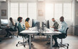 © Flamingo Images - Diverse businesspeople sitting at desks in an office and working on computers