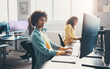 © Flamingo Images - Young businesswoman and coworkers using computers at desks in an office