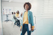 © Flamingo Images - Smiling young businesswoman standing outside a boardroom before a meeting