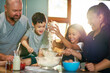 © Caia Image - Happy family baking together in kitchen at home