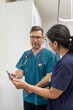 © Austockphoto - Man and woman health care workers  standing next to each other looking on a tablet in the clinic