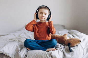 Stylish teen boy listening music in headphones