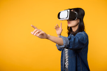 Poster - Young asian woman get experienced wearing virtual reality headset game entertainment isolated on yellow background. Winner of cyber future video game concept.
