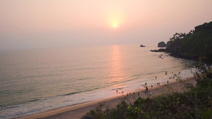 Wall Mural - Wide angle shot of sunset at the Cabo de Rama beach in South Goa, India. View of the beach as seen from above cliff during the sunset. Summer Holidays at beach background. Beautiful sunset at beach