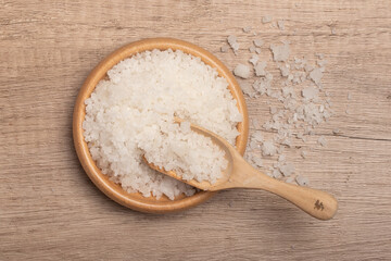 Sea salt in wooden cup on gray background