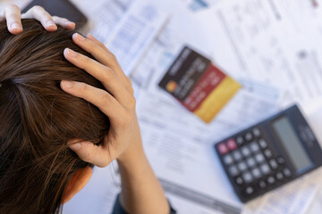 Wall Mural - Financial owe asian woman, female sitting on table at home, stressed and confused by calculate expense from bills, have no money to pay, mortgage or loan. Debt, bankruptcy or bankrupt concept.