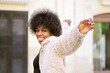 © ADDICTIVE STOCK - Cheerful African America female spinning around on street