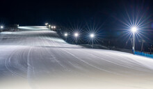 Nighttime At The Illuminated Ski Slope In Ramundberget Resort Area In Sweden With Empty Slopes And No Skier In Newly Groomed Piste.