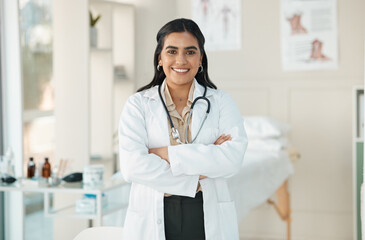 Poster - Lets make you feel better. an attractive young doctor standing alone in her clinic with her arms folded.