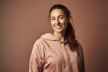 Wall Mural - Portrait of a beautiful young woman in a pink hoodie on a brown background