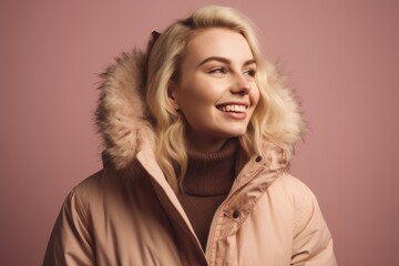 Wall Mural - smiling young woman in winter jacket looking away isolated on pink background