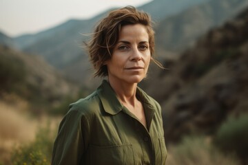 Wall Mural - Portrait of a beautiful woman in a green shirt in the mountains