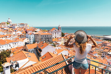Wall Mural - traveler woman, tourist on balcony looking at panoramic view of lisboa- tourism, vacation, travel in