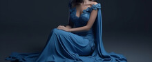 Beautiful Young Woman In Blue Dress On A Dark Background, Studio Shot.generative Ai