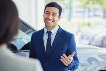 Poster - These are your options. a handsome young male car salesman talking to a female customer on the showroom floor.