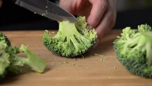 Preparing broccoli for cooking. Cutting broccoli cabbage on a cutting board.