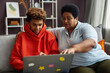 © Seventyfour - African American mature woman and diligent teenage boy looking at laptop screen while watching online video or discussing information