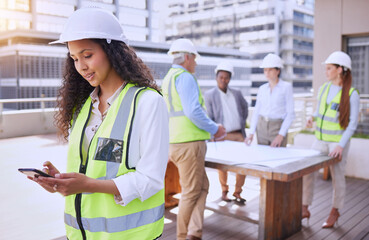 Aufkleber - Checking site updates. an attractive young female construction worker using a cellphone while standing outside with her team in the background.